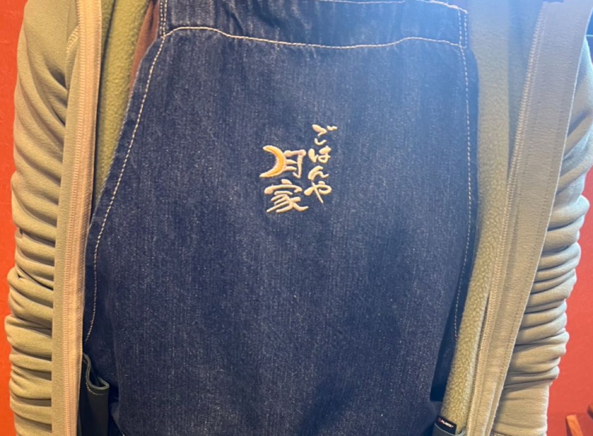 デニムエプロンに入れたオレンジ糸の和文字刺繍