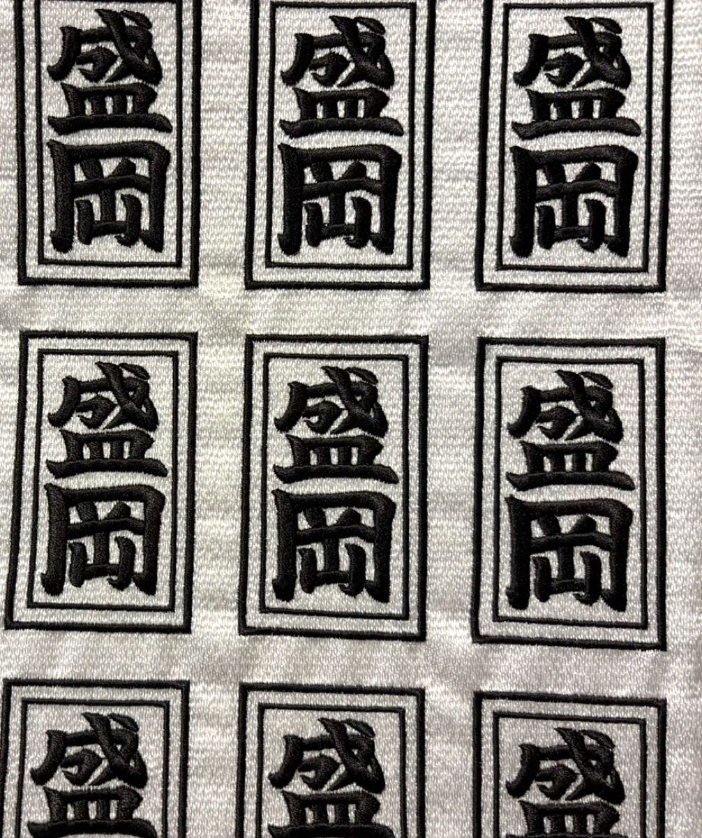 同じ文字の刺繍を生地の上に多面で並べて縫った様子