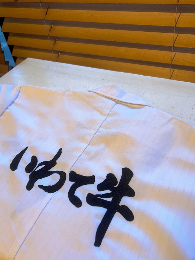 白い作業着の背中に大きく「いわて牛」と入れた刺繍